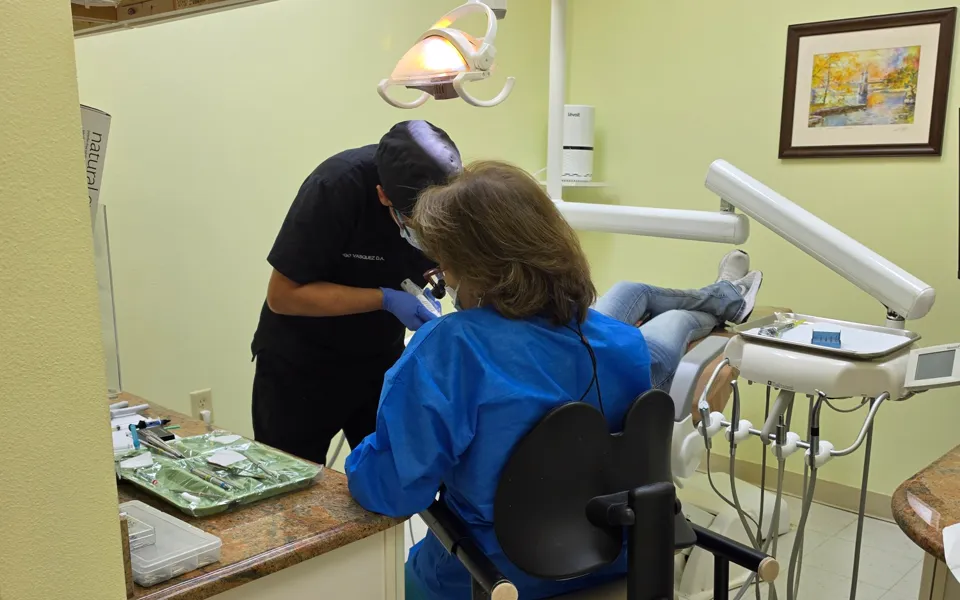 Dental team treating a patient in a practice operatory